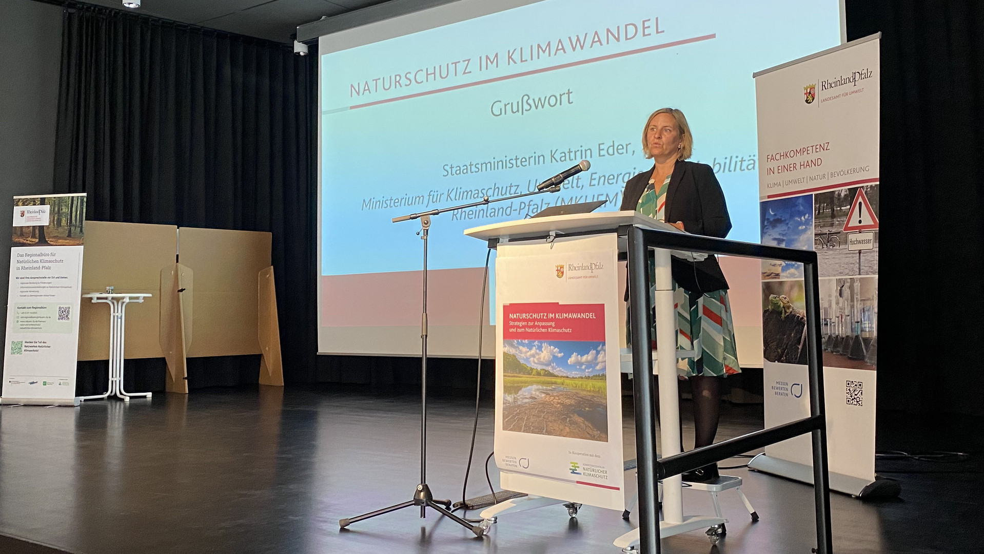 Rednerin am Pult, im Hintergrund Präsentation