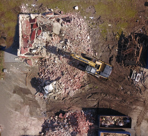 Bagger reißt Haus ein. Aufnahme von oben