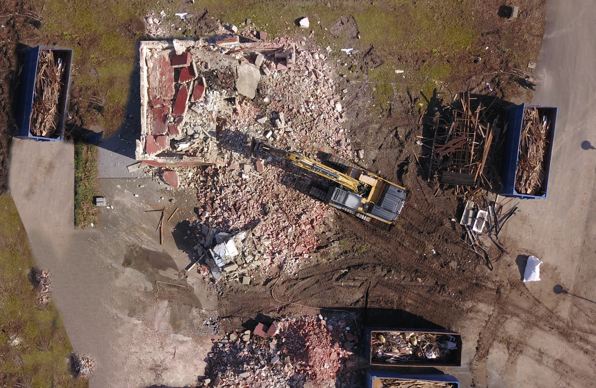 Bagger reißt Haus ein. Aufnahme von oben