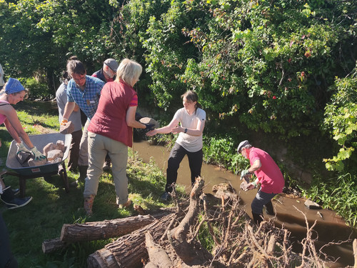 Teilnehmer arbeiten im und am Bach