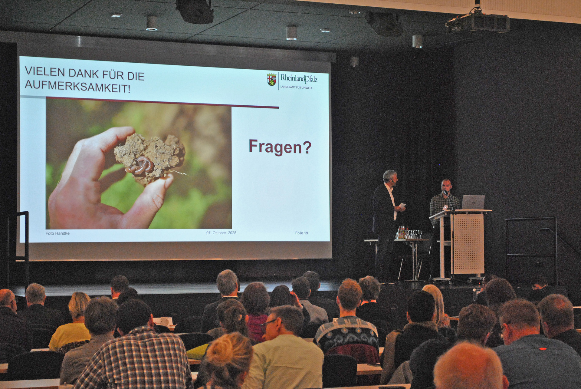 Referent am Podium, Präsentation auf der Leinwand